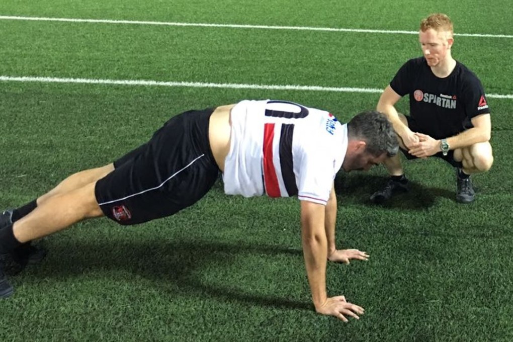 Andrew Power instructs Post reporter Jonathan White on the burpee. Photos: Handout