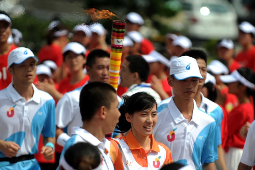 A Shenzhen University student carries the torch of the 26th Summer Universiade, held in Shenzhen in 2011. Sporting events in the Greater Bay Area could help build camaraderie among youth. Photo: Xinhua