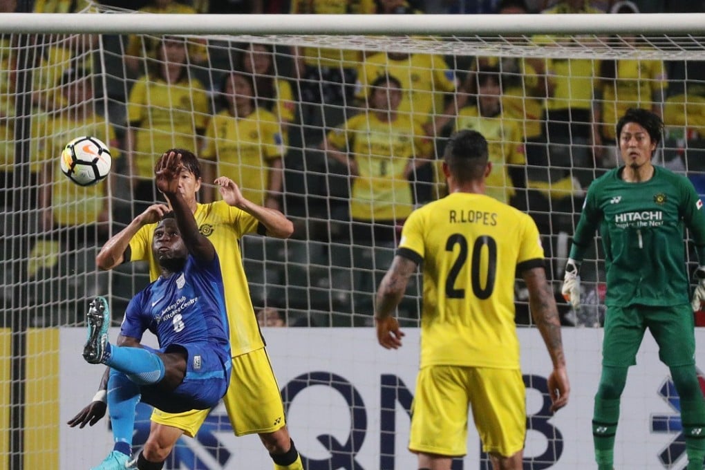 Kitchee Alex Akande (in blue) tries to score with his back to the net against Kashiwa Reysol. Photos: Winson Wong