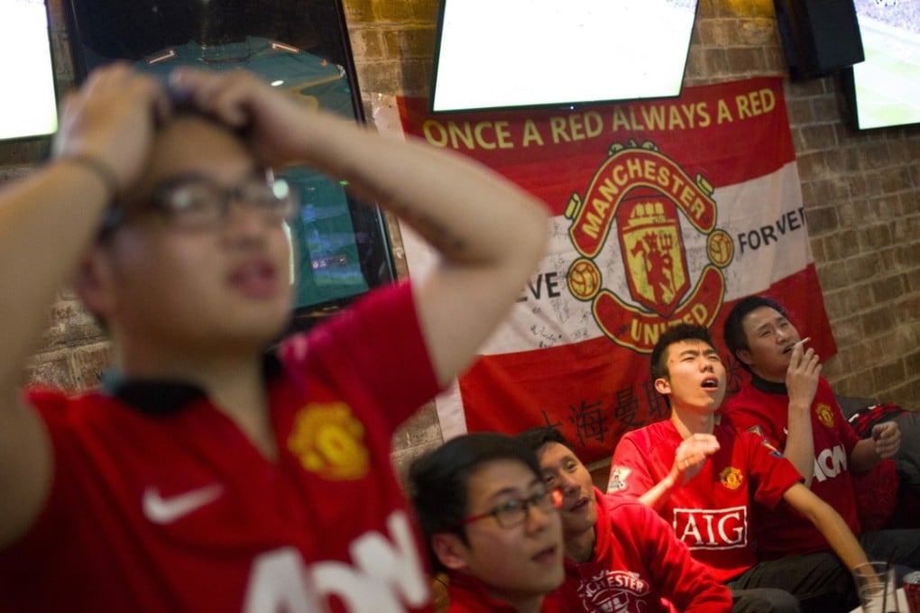 Members of the Manchester United Shanghai fan club react as they watch a telecast of the team on TV. Photo: Reuters