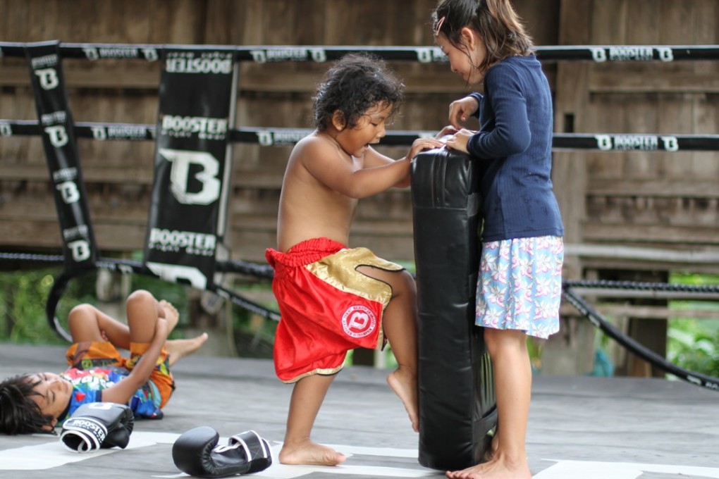 Children help each other learn Muay Thai at Frances and Boom Watthanaya’s gym in northeast Thailand. Photo: Wor. Watthana