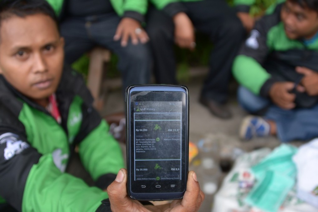 A motorcycle driver displays the popular ride-hailing app by Indonesian start-up Go-Jek on his smartphone in Jakarta. Photo: Agence France-Presse
