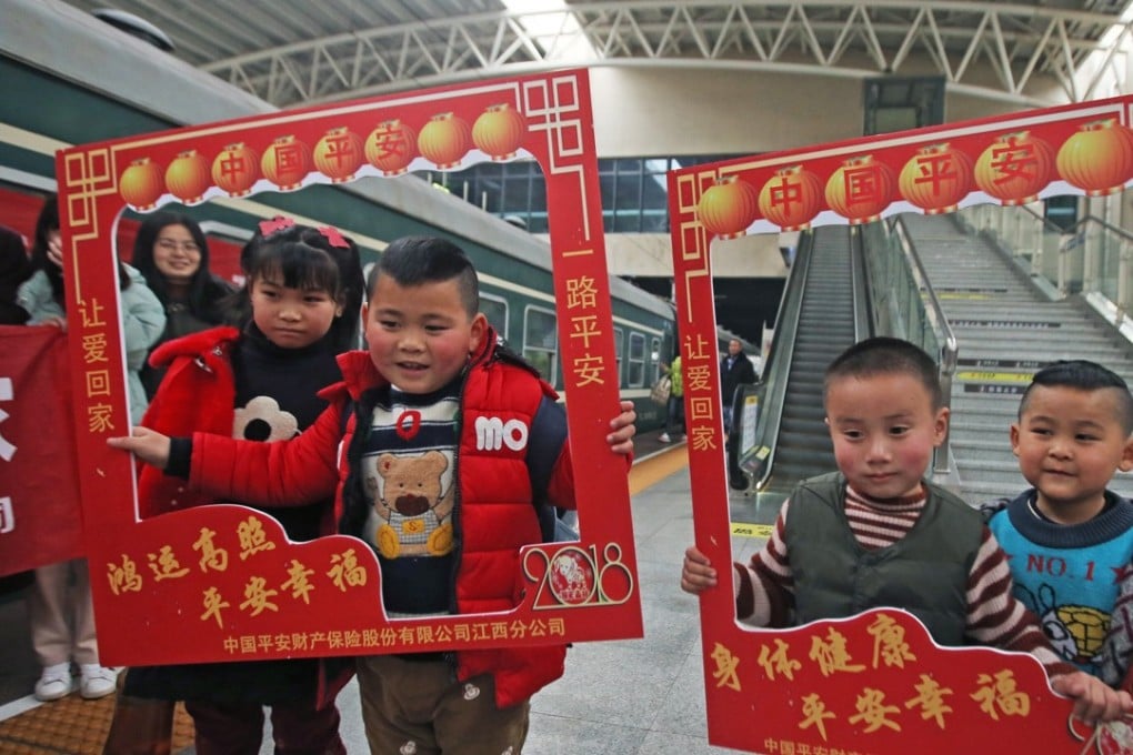 Children of migrant workers pose for photos before boarding a train from Shantou to Nanchang on February 10, heading home for family reunions to mark the Lunar New Year. Photo: Xinhua