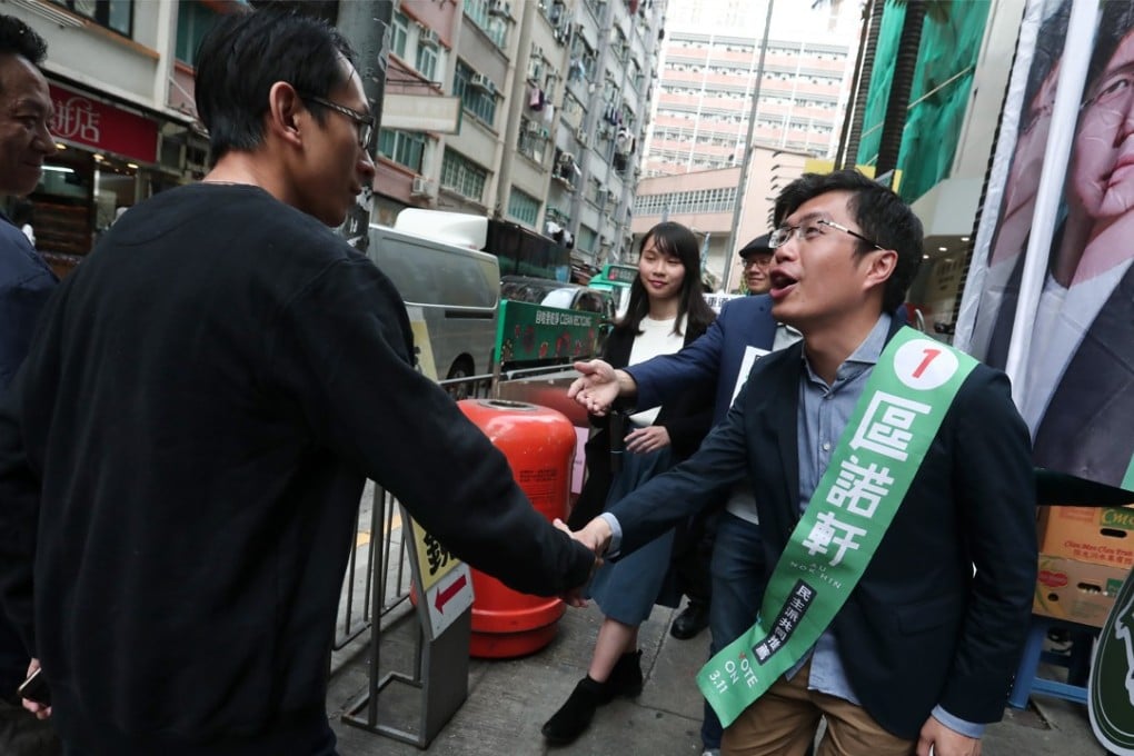 Candidate Au Nok-hin (right), who won the Hong Kong Island constituency for the Legislative Council By-election, shakes hands with one of his voters in Shek Tong Tsui. Photo: Jonathan Wong