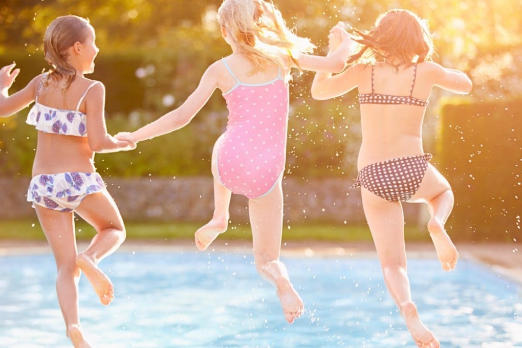 Group of girls playing in outdoor swimming pool. Photo: Alamy