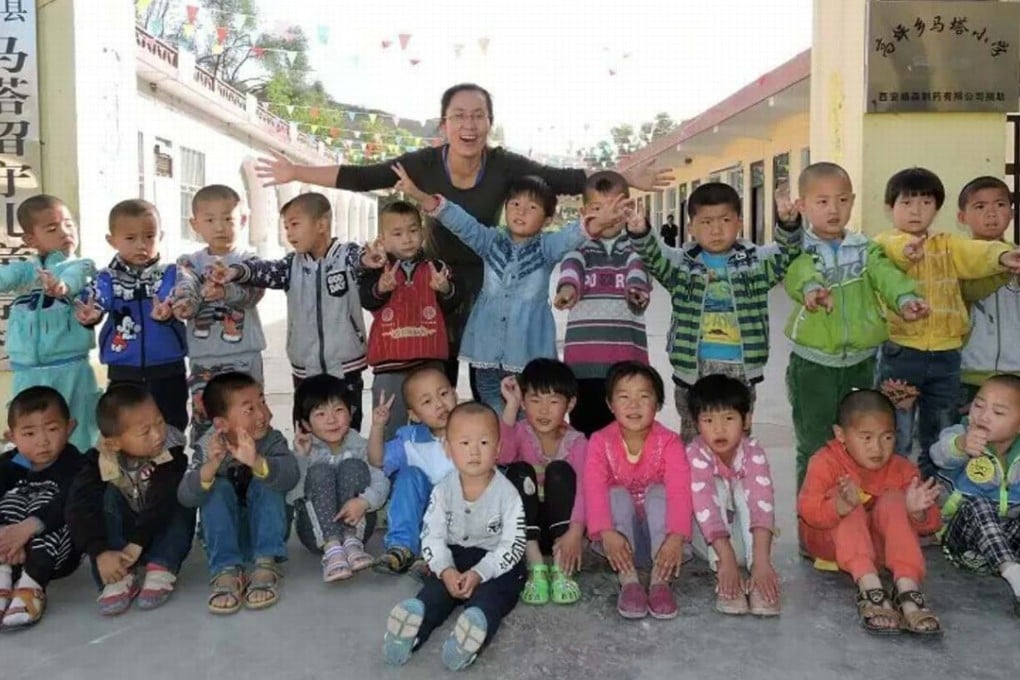 Ma Jun poses with pupils at the gate of Mata School in 2015. Photo: Handout