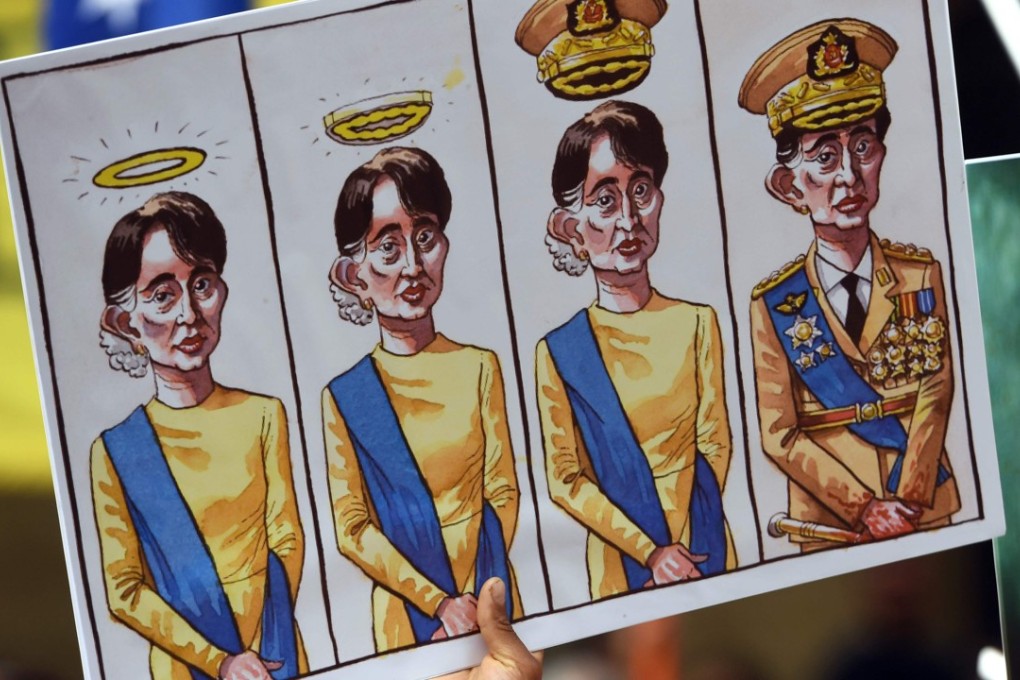 Posters with cartoons featuring Myanmar’s State Counsellor Aung San Suu Kyi are held up at a protest in Sydney on March 17, 2018. Photo: AFP