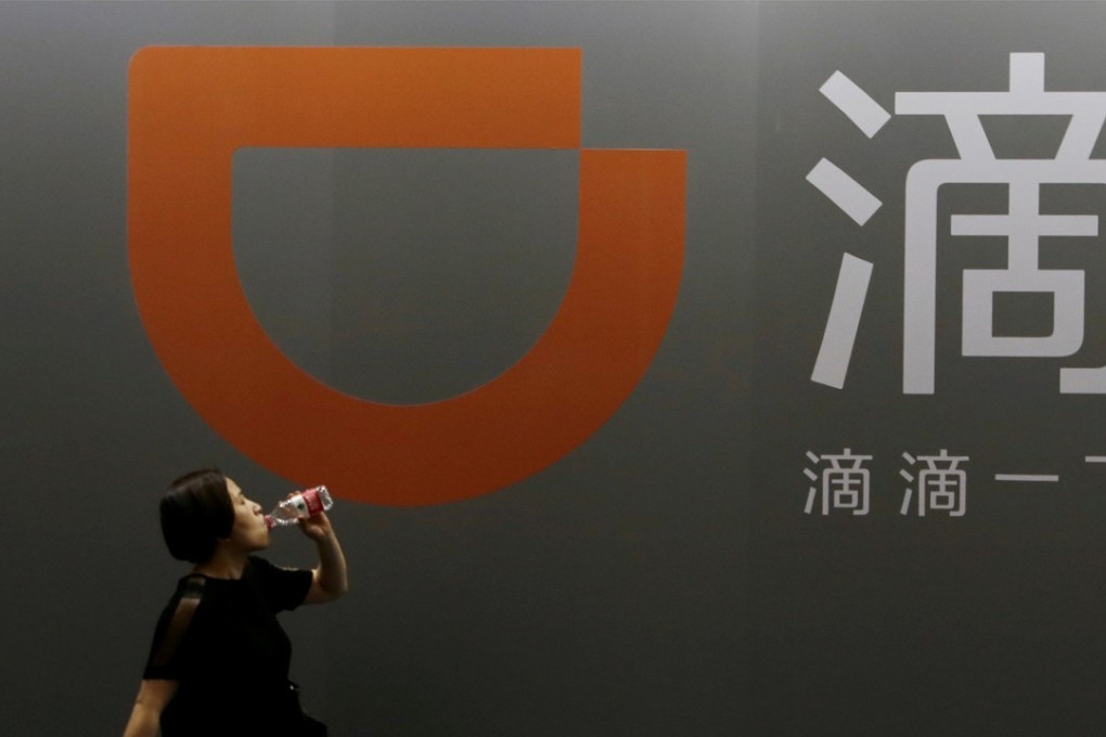 A woman walks past Didi Chuxing's booth at the Global Mobile Internet Conference in Beijing. Photo: Reuters
