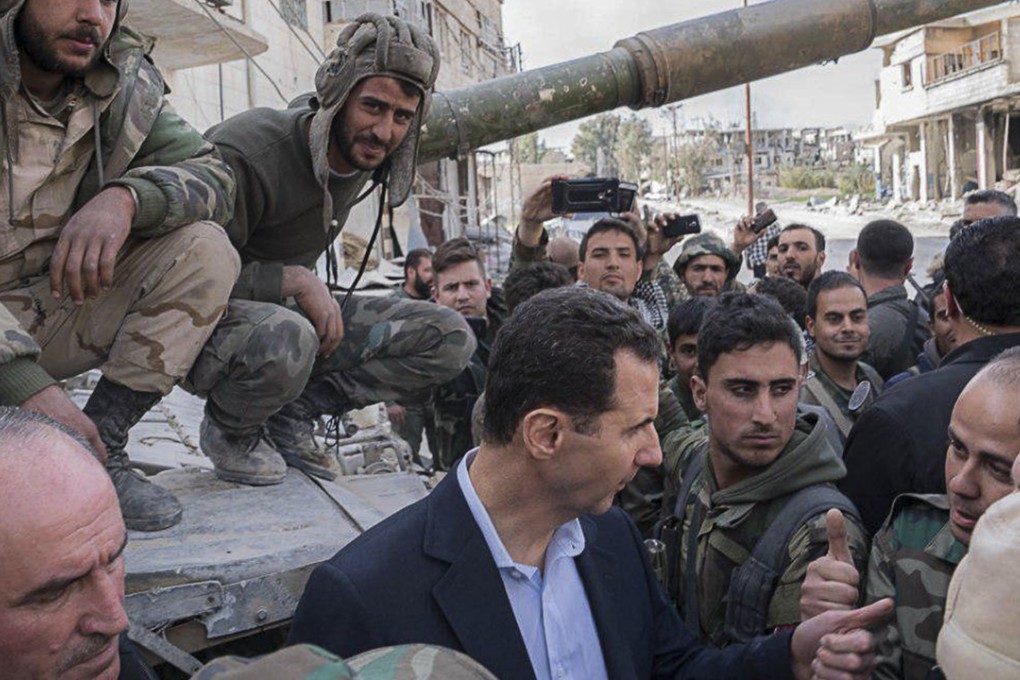 A handout photo made available by the official Syrian Arab News Agency (SANA) shows Syrian president Bashar Al-Assad meeting with Syrian army soldiers, in eastern Ghouta, on March 18, 2018. Photo: SANA handout via EPA-EFE