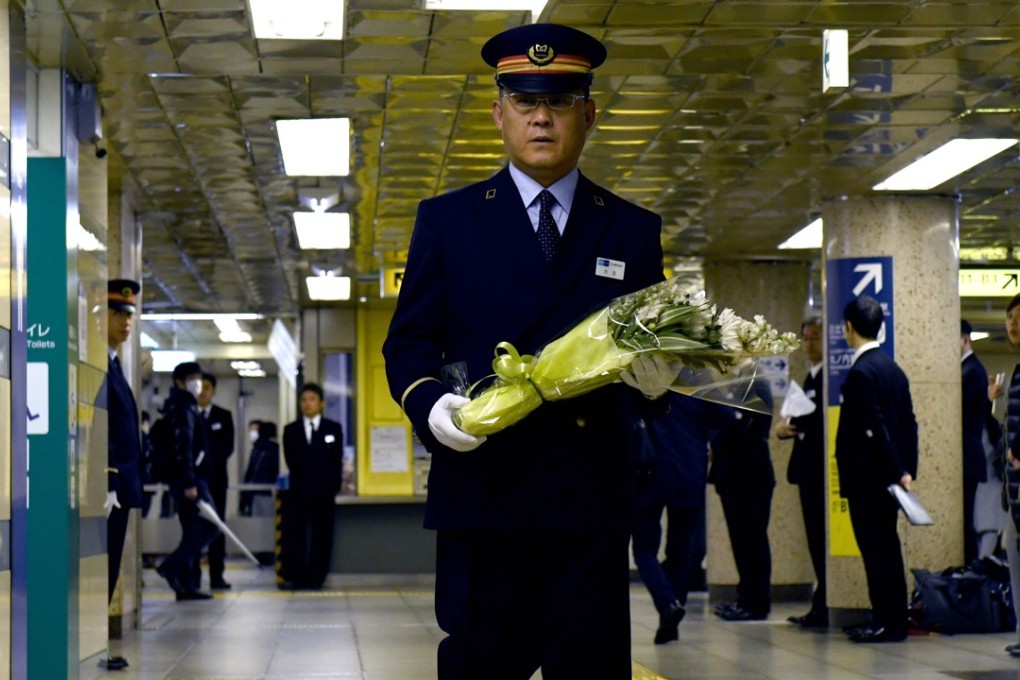 Kasumigaseki subway station manager Toyohiko Otomo walks with a bouquet of flowers towards an alter to mourn the victims of the 1995 sarin gas attack by Aum Supreme Truth doomsday cult at the station in Tokyo. Photo: AFP