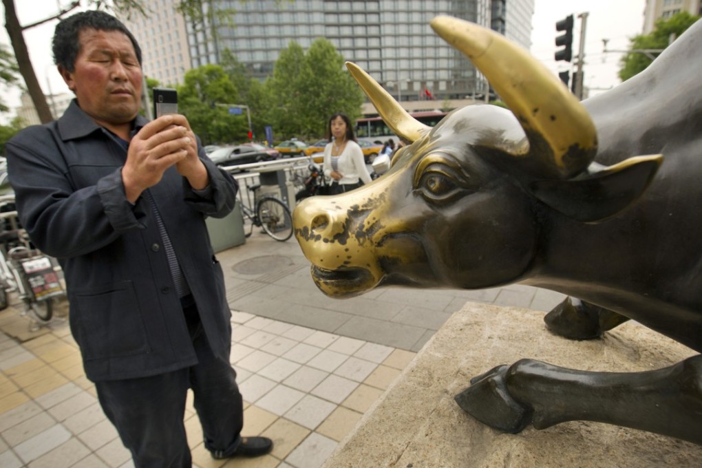 A Chinese tourist takes a photo of a statue of a bull in Beijing. China’s small caps have rallied this year, reversing an 11 per cent decline in 2017. Photo: AP