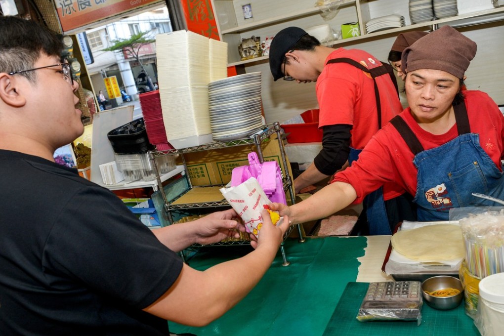 A customer receives his food order from a staff member at Liang Chen Chi Shih breakfast bar in Taipei. Photo: Chris Stowers
