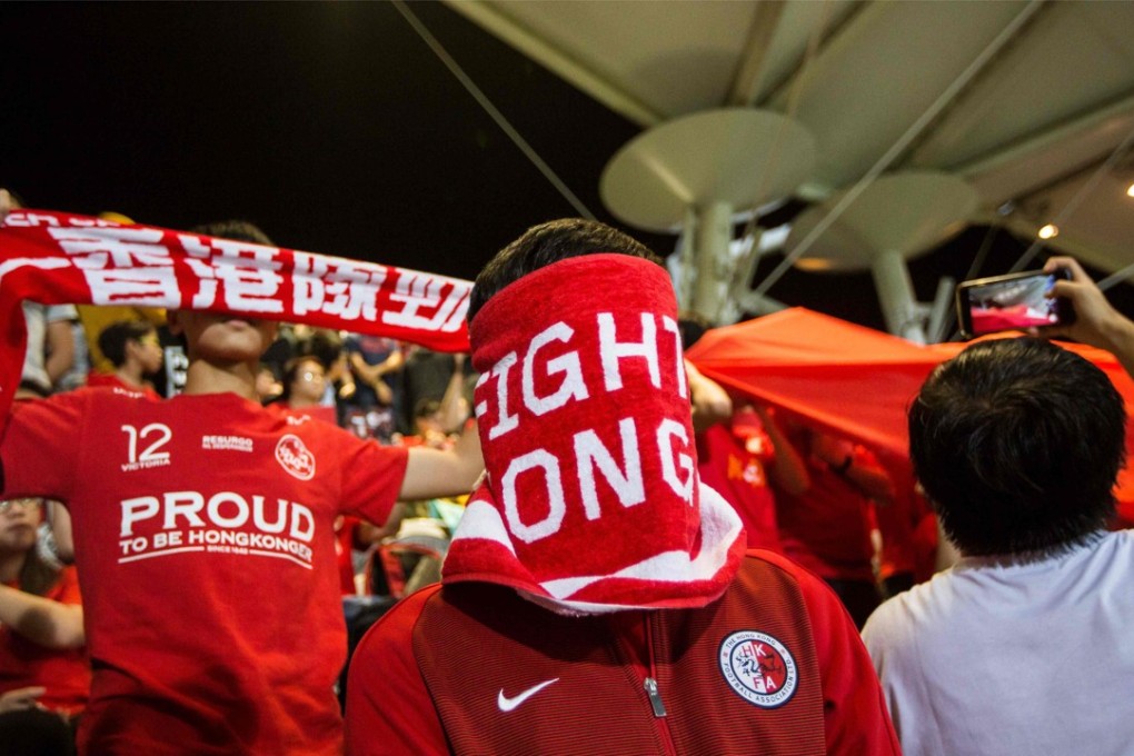 A Hong Kong fan covers his face during the Chinese national anthem before a friendly soccer match between Hong Kong and Bahrain at Mong Kok Stadium on November 9, 2017. China passed a law under which anyone disrespecting the national anthem could be punished with up to three years in prison and Hong Kong is expected to enact a local version of the legislation. Hong Kong soccer fans have booed the anthem when it is played at matches since 2015. Photo: AFP