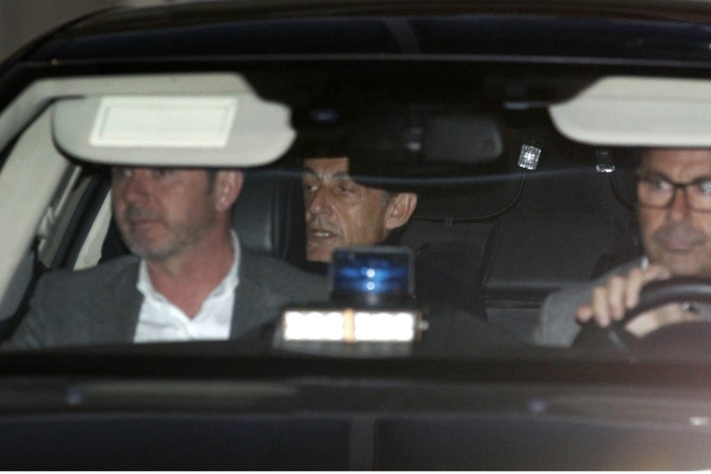 Former French president Nicolas Sarkozy, centre, leaves the police station where he was held, in Nanterre, outside Paris, on Wednesday. Photo: AP