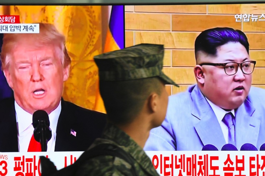 A South Korean soldier walks past a television screen showing pictures of US President Donald Trump (left) and North Korean leader Kim Jong-un at a railway station in Seoul on March 9. Trump agreed on March 8 to a historic first meeting with Kim. Photo: AFP