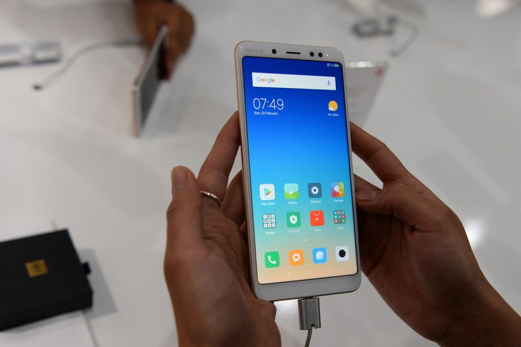 An Indian consumer holds the recently launched Xiaomi Redmi Note 5 Pro smartphone during a promotional event in New Delhi last month. Photo: Agence France-Presse