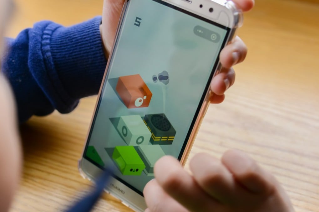 A boy plays platform-jumping mobile game Tiao yi tiao, which roughly translates to “Jump Jump”. The game, which is available as an application through Tencent Holding’s multi-purpose WeChat service, has recorded more than a 100 million daily active users since it was introduced in December last year. Photo: WeChat