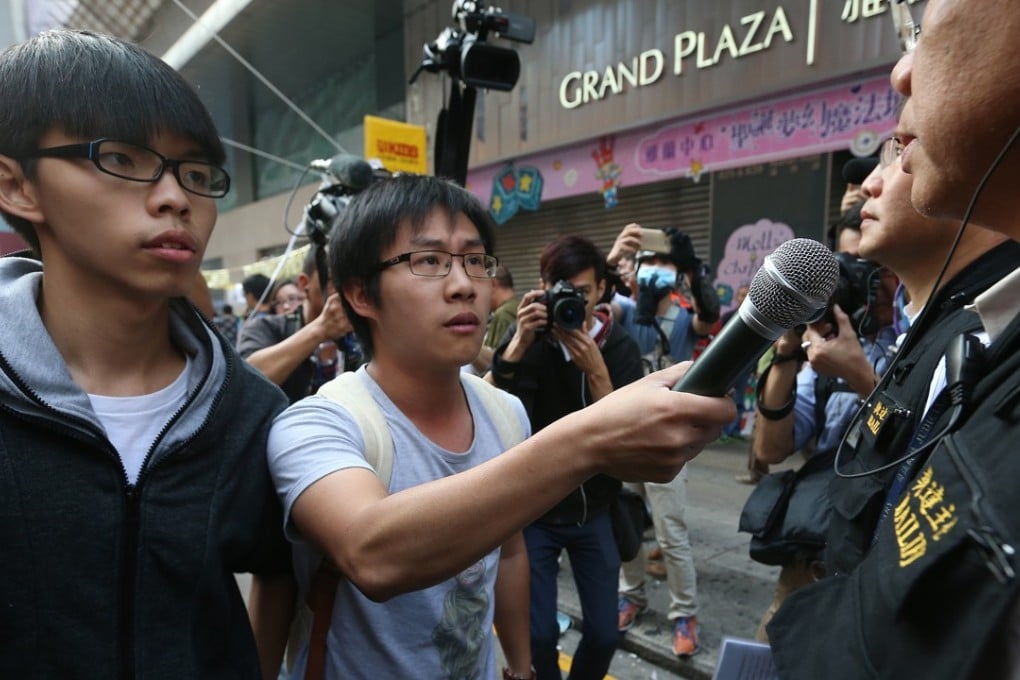 Scholarism convenor Joshua Wong Chi-fung (left) and Raphael Wong Ho-ming (centre) of the League of Social Democrats at a clearance operation at Mong Kok occupied site. Photo: K.Y. Cheng