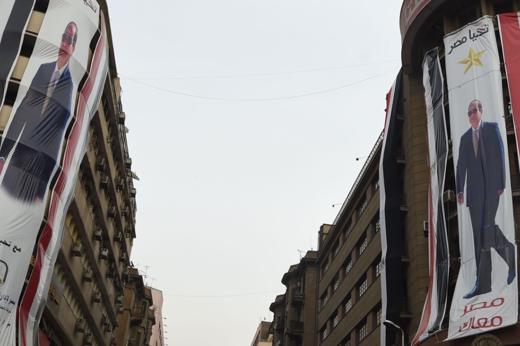 Giant election campaign posters supporting Egyptian President Abdelfattah al-Sisi hang in Cairo. Bel Trew, a journalist with The Times, was arrested on 20 February in what many say is a crackdown on dissent ahead of the election. Photo: AFP