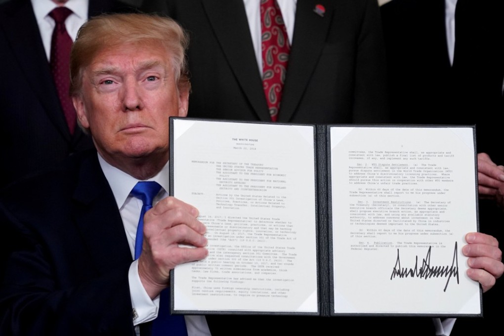US President Donald Trump holds his signed memorandum on intellectual property tariffs on high-tech goods from China, at the White House in Washington on Thursday. Photo: Reuters