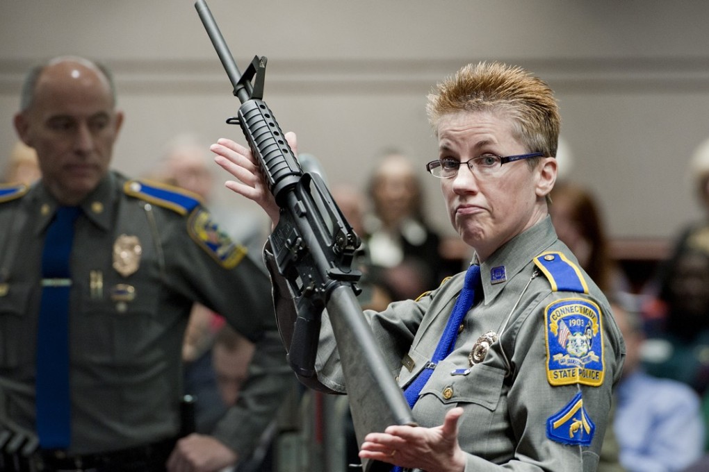 In this January 28, 2013, file photo, firearms training unit Detective Barbara J. Mattson, of the Connecticut State Police, holds up a Remington Bushmaster AR-15 rifle, the same make and model of gun used by Adam Lanza in the Sandy Hook School shooting, for a demonstration at the Legislative Office Building in Hartford. Photo: AP