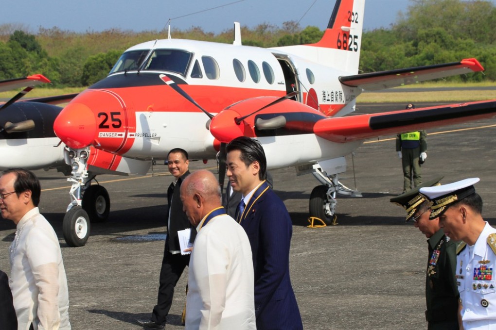 Philippine National Defence Secretary Delfin Lorenzana (centre front) chats to Japan’s Vice-Minister for Defence Tatsuo Fukuda as they walk past one of the three Beechcraft TC90 aircraft transferred to Manila by Tokyo. Photo: Reuters
