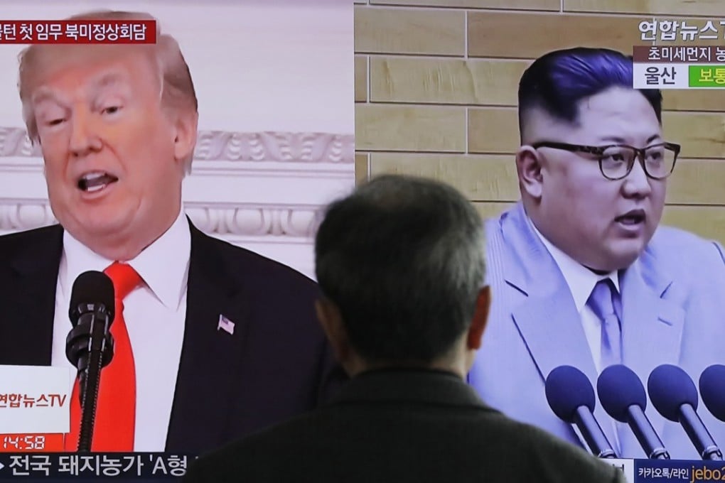 A man watches a TV screen showing file footage of Donald Trump and Kim Jong-un at the Seoul railway station on Tuesday. The two leaders have agreed to meet in May. Photo: AP