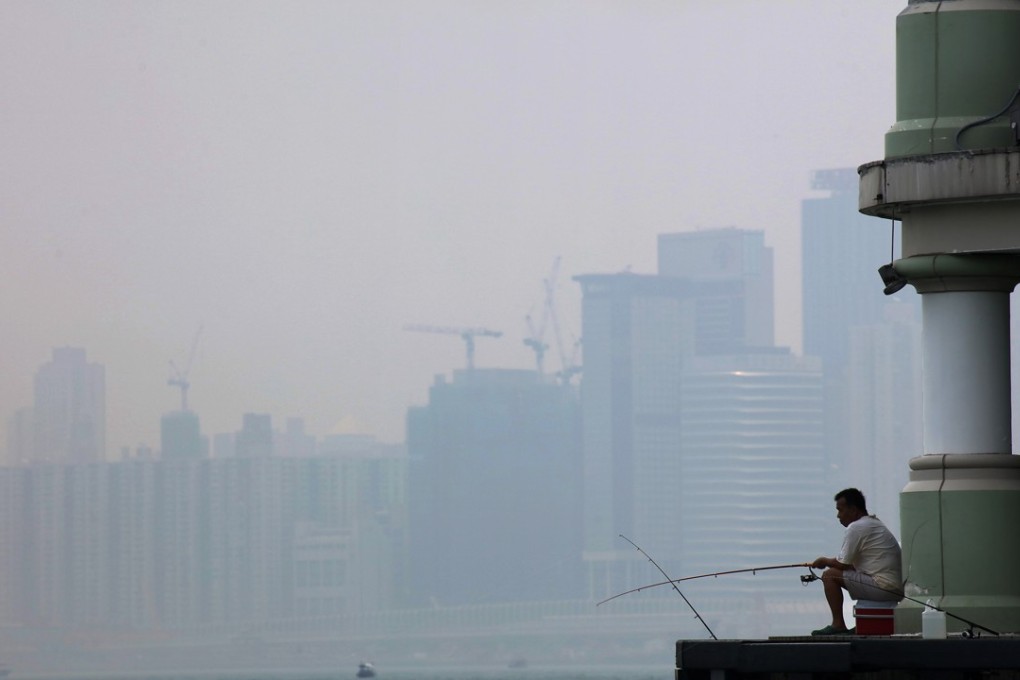 A local resident fishes at Victoria Harbour in July 2017, on a day when Hong Kong recorded “very high” to “serious” levels of air pollution across the city. Photo: Felix Wong