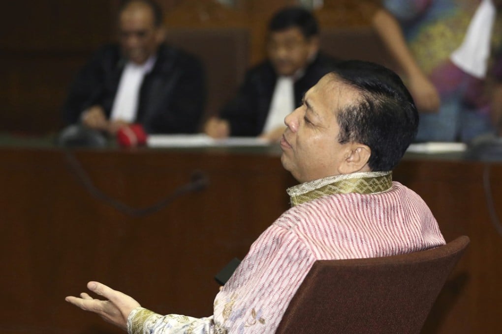 Former speaker of Indonesia's parliament Setya Novanto, centre, gestures after a break during his trial the Corruption Cases Court in Jakarta, Indonesia, Thursday, March 29, 2018. The top Indonesian politician was accused of involvement in a conspiracy of dozens of officials who used the introduction of an electronic ID system to steal more than $170 million of public money. (AP Photo/Achmad Ibrahim)