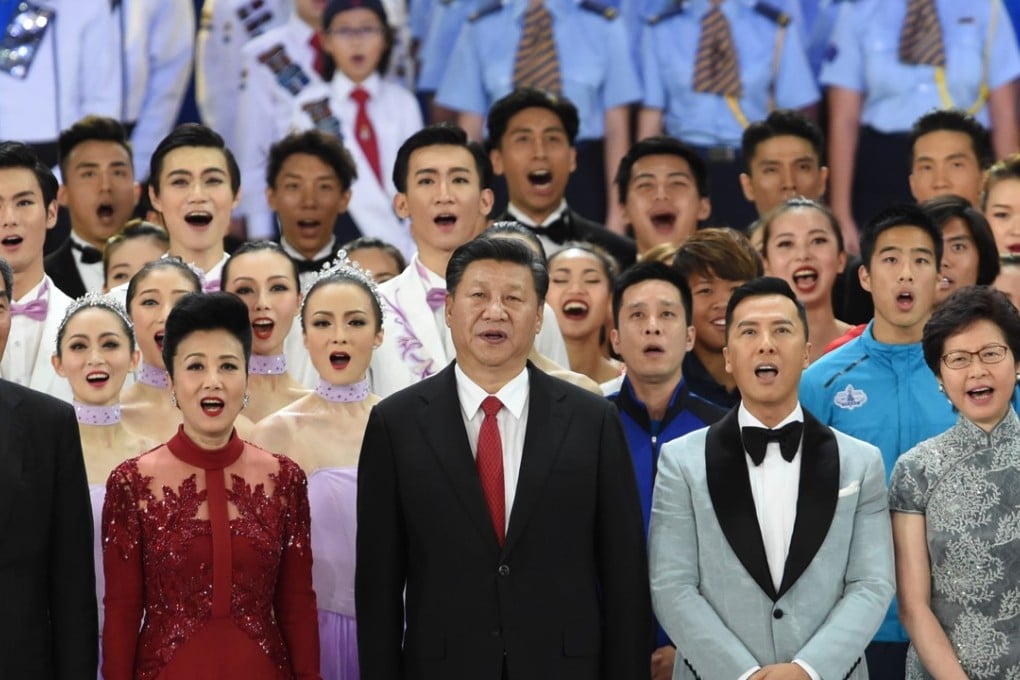 President Xi Jinping (centre) joins Hong Kong’s then outgoing chief executive Leung Chun-ying (far left) and his successor, Carrie Lam Cheng Yuet-ngor (right) in singing the song, My Country, flanked by Hong Kong performer Lisa Wang and actor Donnie Yen, in Hong Kong last June 30. PHoto: AFP