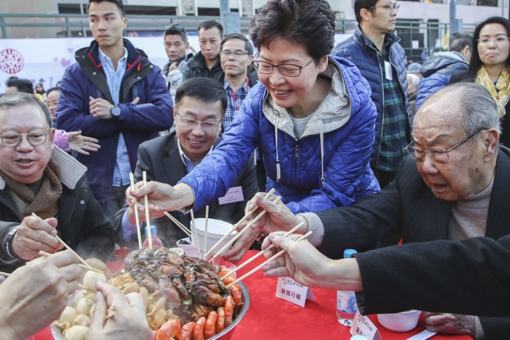 Hong Kong Chief Executive Carrie Lam Cheng Yuet-ngor joins He Jing, deputy director of the central government’s liaison office (centre), tycoon Peter Lam Kin-ngok (far left), and members of the community in a poon choi feast for the elderly, in Kennedy Town on January 13. Photo: Edward Wong