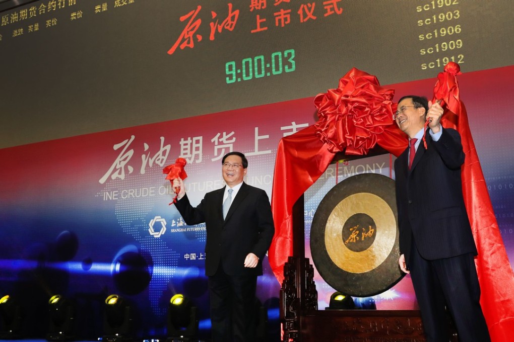Li Qiang (left), the Communist Party chief of Shanghai, and Liu Shiyu, chairman of the China Securities Regulatory Commission, hit the gong together to open the trading session for renminbi-dominated crude oil futures contracts, at the Shanghai International Energy Exchange on March 26. Photo: Xinhua
