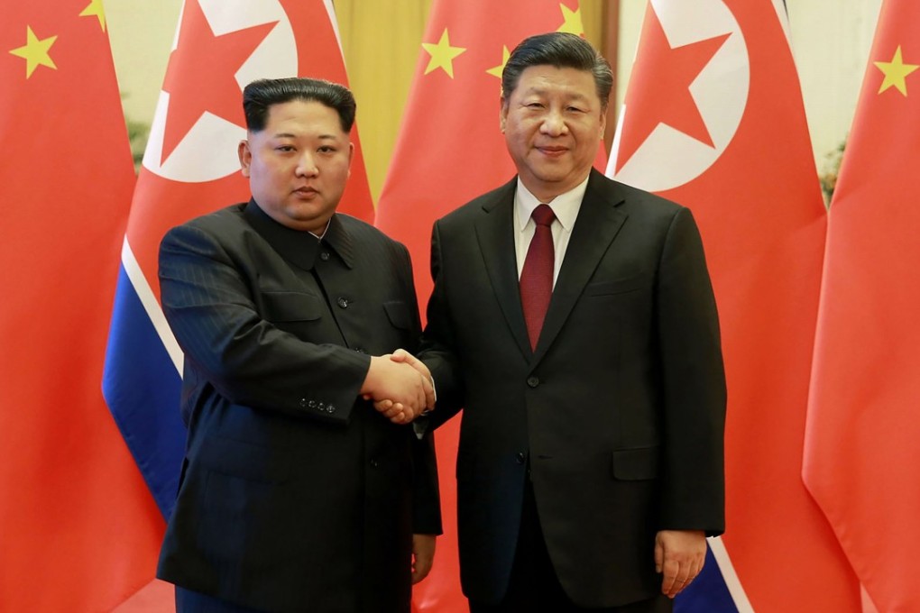 Kim Jong-un (left) shakes hands with Xi Jinping during their meeting in Beijing on Monday. Photo: AFP/KCNA via KNS