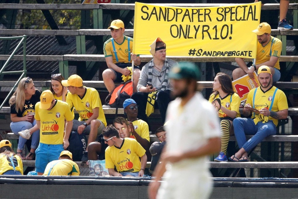 South African fans hold a banner as they mock Australia cricket players during day one of the fourth cricket test. Photo: AFP