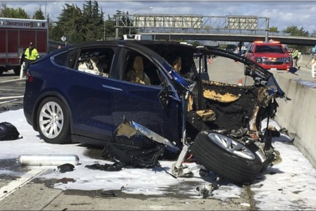 Emergency personnel work a the scene where a Tesla electric SUV crashed into a barrier. Photo: AP