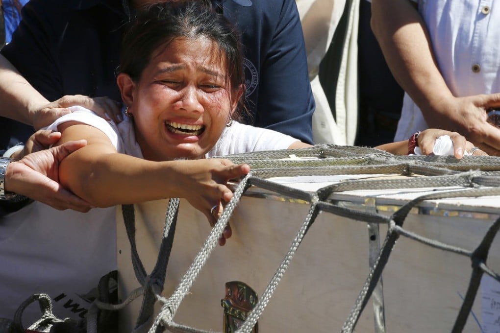 Jessica Demafelis, the sister of Joanna Demafelis, who was found dead in a freezer in Kuwait, cries as the wooden casket of her remains arrives at the Ninoy Aquino International Airport. Photo: AP
