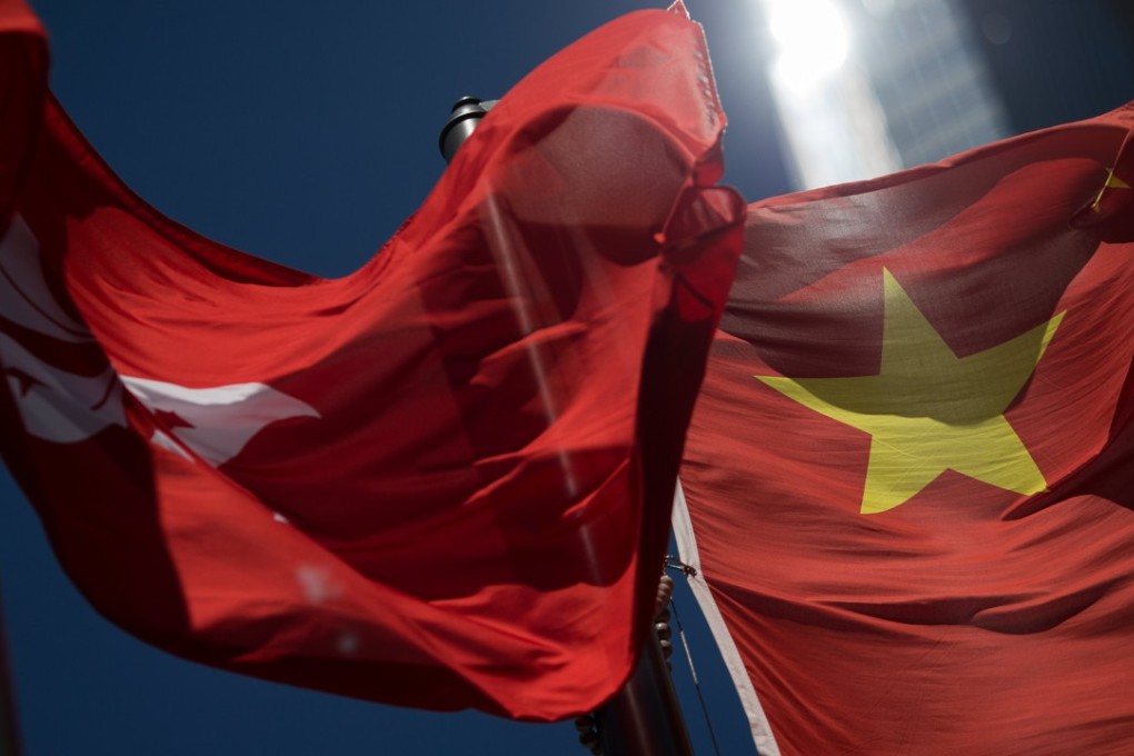 The Hong Kong and China flags flutter side-by-side, outside the Hong Kong stock exchange. Photo: EPA
