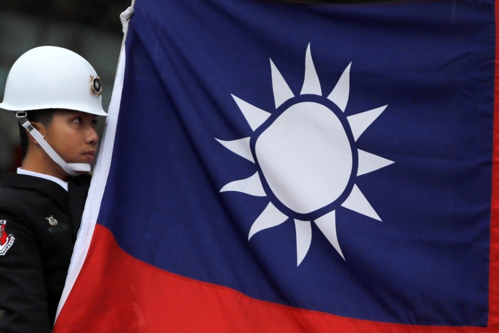 A military honour guard holds a Taiwanese national flag at a flag-raising ceremony at Chiang Kai-shek Memorial Hall in Taipei last month. Photo: Reuters