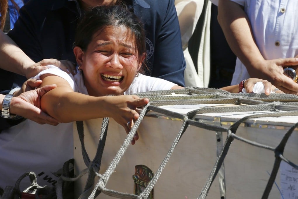Jessica Demafelis, the sister of Joanna Demafelis who was found dead in a freezer in Kuwait, cries as the wooden casket of her remains arrives in Pasay city, southeast of Manila. Photo: AP