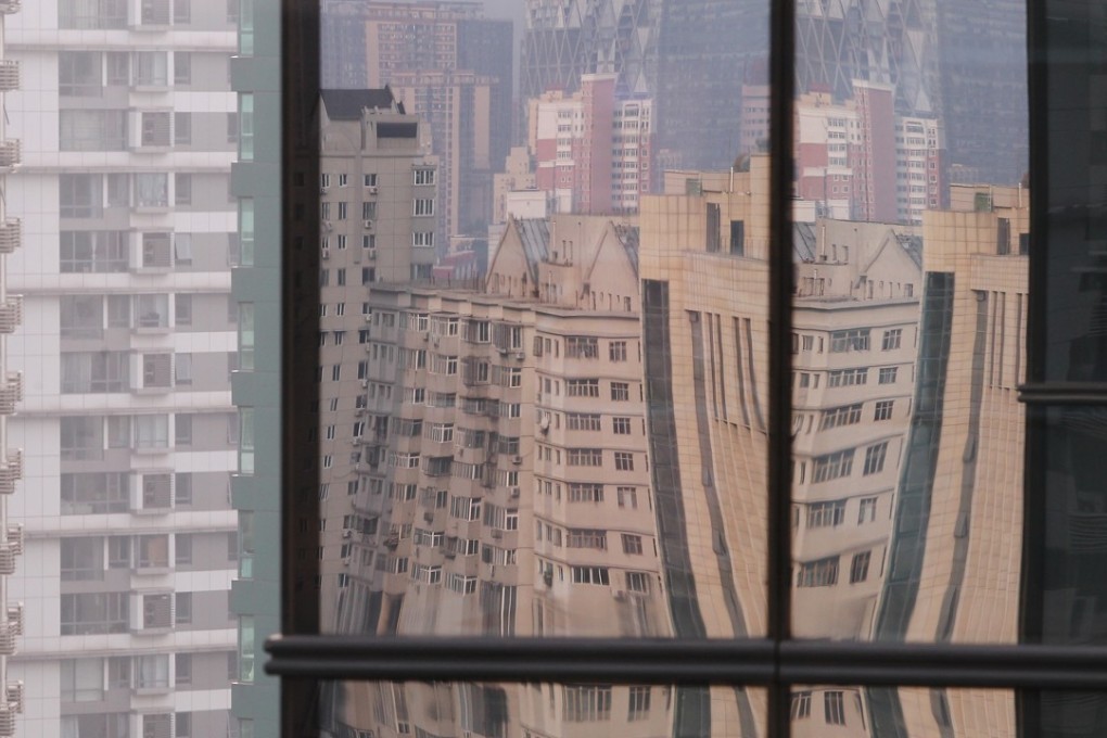 Residential blocks reflected in the glass wall of a high-rise building in Beijing’s central business district. Photo: SCMP