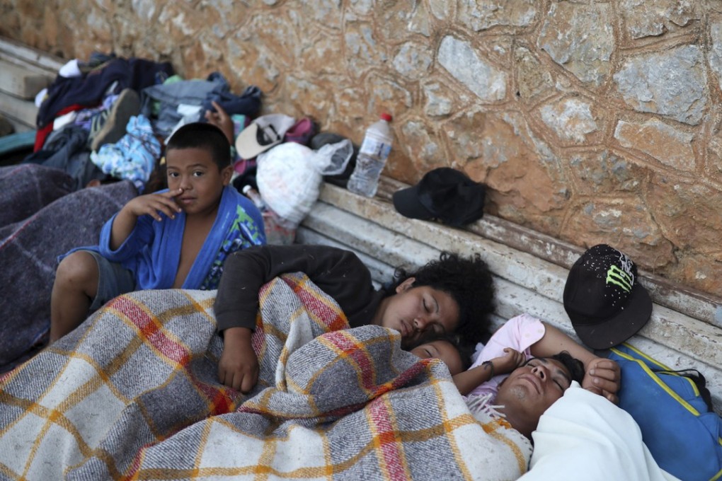 A boy sits awake as Central American migrants traveling with the annual "Stations of the Cross" caravan sleep at a sports club in Matias Romero on Tuesday. Photo: AP