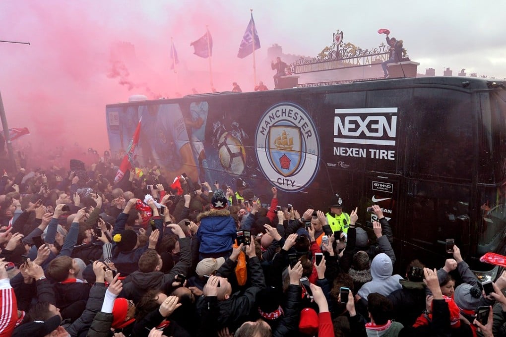 Liverpool supporters ignite red flares as the Manchester City team bus arrives to a heated reception at the gates of Anfield. Photo: EPA