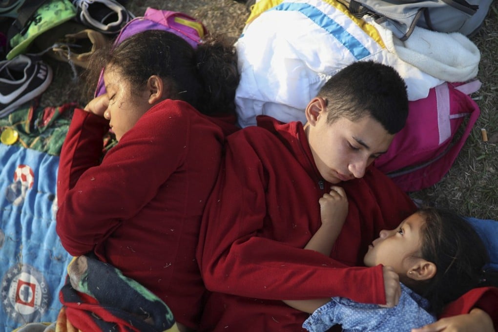 The Zelaya siblings from El Salvador – Nayeli, right, Anderson, centre, and Daniela – sleep huddled together Wednesday on a soccer field where Central American migrants travelling with the annual ‘Stations of the Cross’ caravan are camped out, in Matias Romero, Oaxaca state, Mexico. Photo: AP