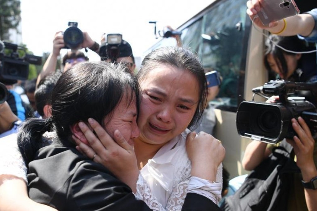 Liu Chengying (left) embraces her daughter Kang Ying during their reunion in Chengdu, as the press watch on. Photo: Xinhua