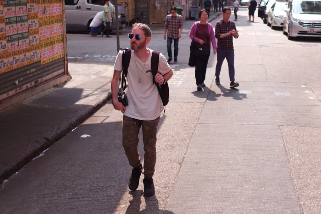 Artist Joshua Smith walking the streets of Hong Kong. The maker of miniature building models says he is inspired by urban decay.