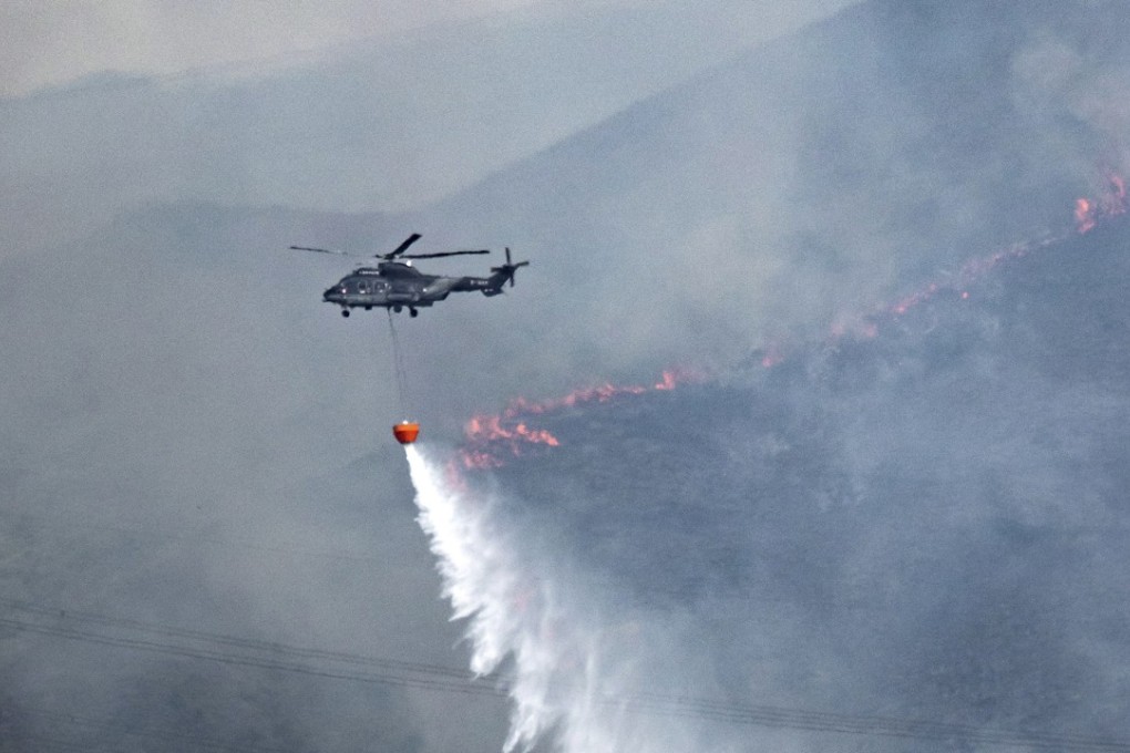 The Government Flying Service deploys a helicopter to drop water on a fire at Kong Tau Tsuen in Yuen Long. Photo: Keith Mulcahy