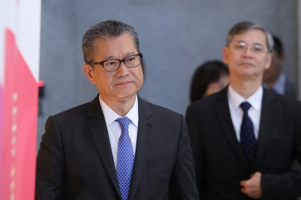 Financial Secretary Paul Chan Mo-po arrives to speak to the media after announcing that a third of Hongkongers will get a cash handout of up to HK$4,000 each, as Labour and Welfare chief Law Chi-kwong follows behind, at the Hong Kong government headquarters, in Admiralty on March 23. Photo: Sam Tsang