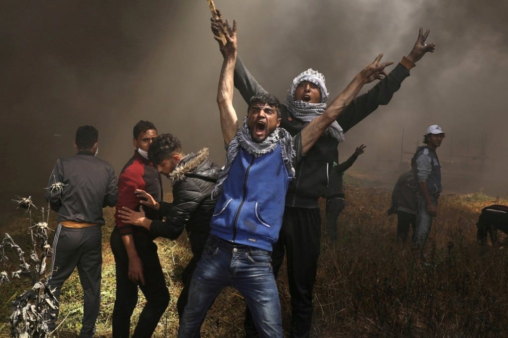 Palestinian demonstrators shout during clashes with Israeli troops at protests near the Israel-Gaza border. The clashes have left dozens dead, including well known journalist Yasser Murtaja. Photo: Reuters