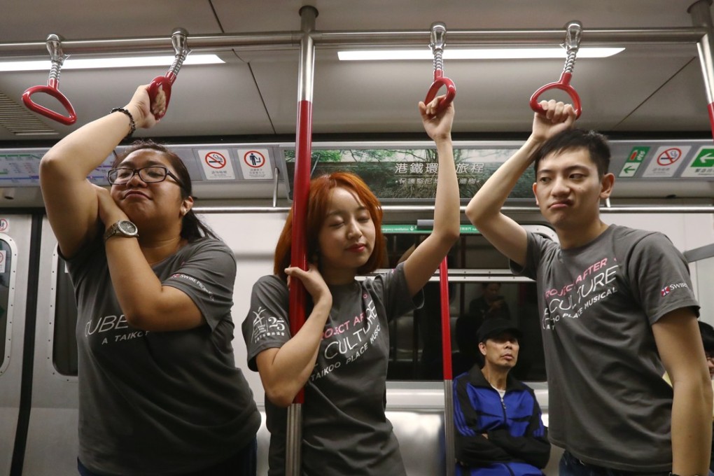 Joan Odita (left) Ki and Michael Cheung Cheuk-lam ride the MTR ahead of the opening of Project After 6: Cube Culture. Photo: Nora Tam
