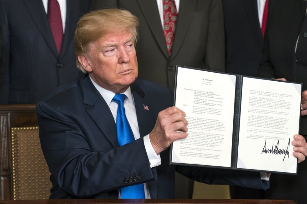 US President Donald Trump raises a presidential memorandum targeting what the White House termed “China’s economic aggression”. Photo: EPA-EFE